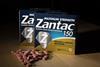 An image showing a photo illustration of a Zantac box and drug tablets